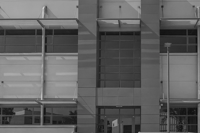 Modern building entrance with large windows and a tall streetlamp in front. Quantum Switch Data Centre, Qatar.