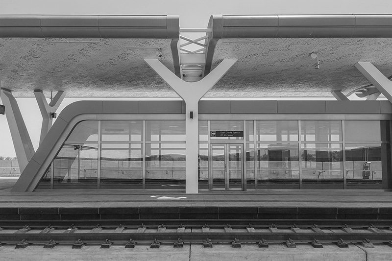 Modern train station platform with glass walls and Y-shaped support columns. Lusail Light Rail Transit, Doha, Qatar.